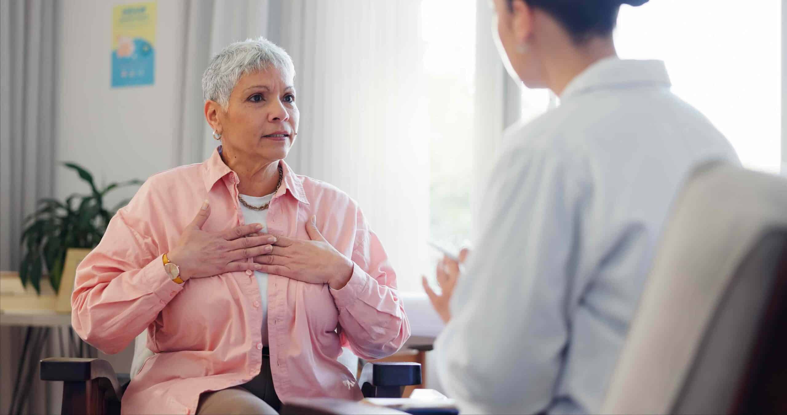 Doctor, Consultation And Elderly Woman With Chest Pain For Heart Disease, Advice And Medical Checkup